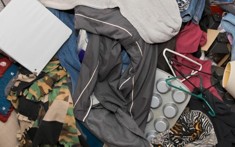 Cluttered pile of clothes and miscellaneous items.