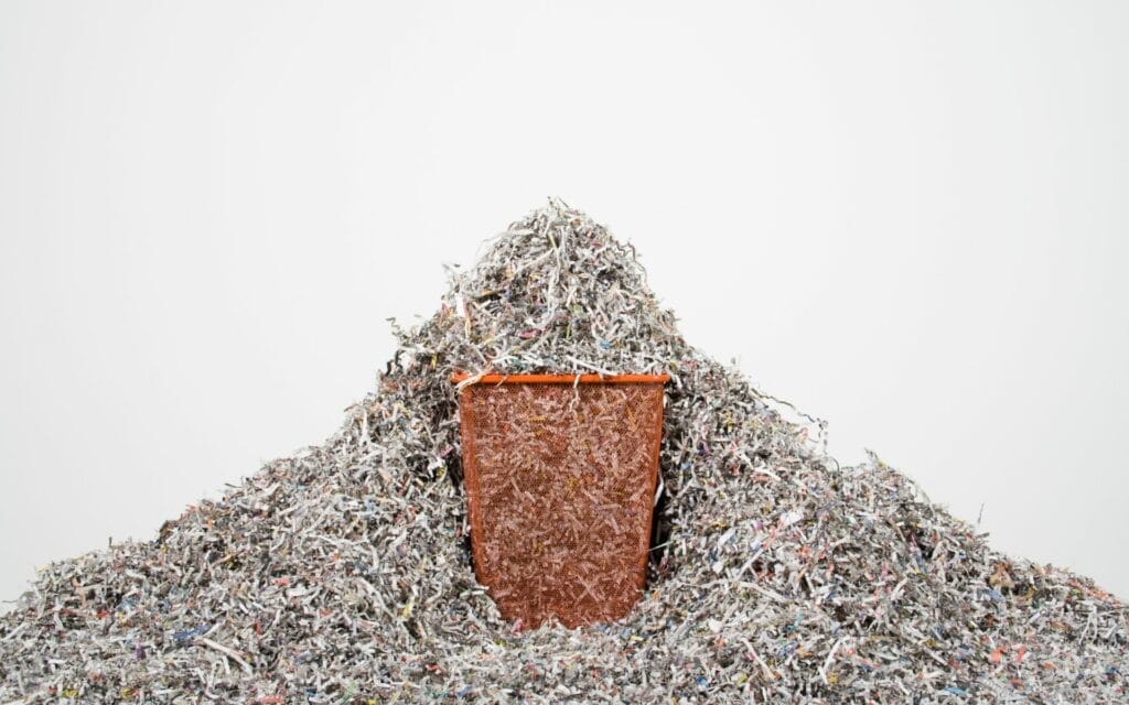 Trash can overflowing with shredded paper
