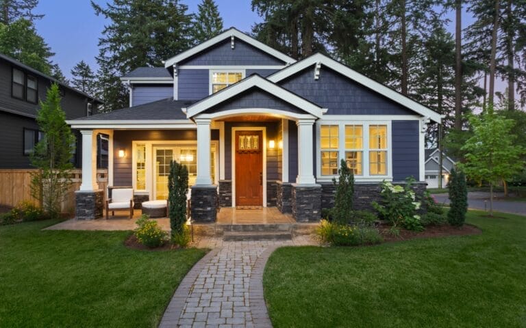 Charming suburban house with illuminated entrance at dusk.