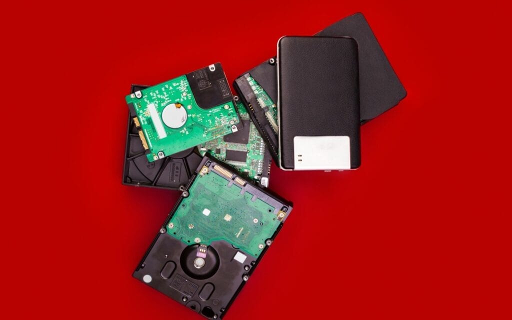 Assorted hard drives on red background