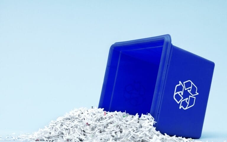Blue recycling bin with shredded paper