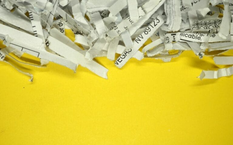 Shredded paper strips on bright yellow background.