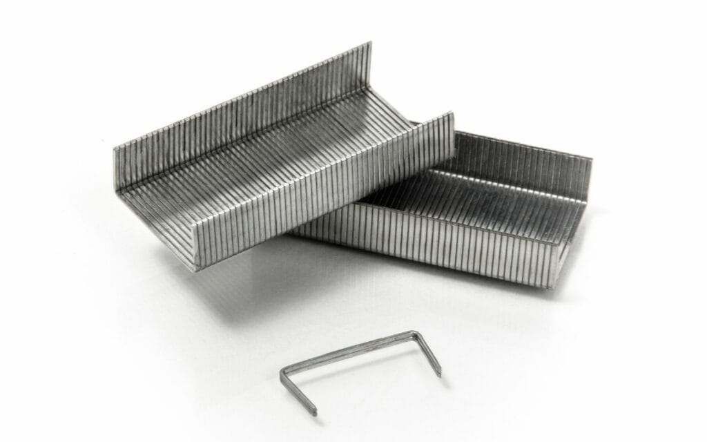 Close-up of metal staples on white background.