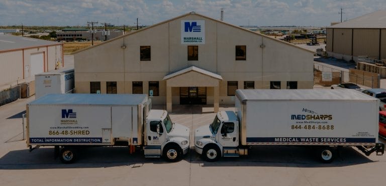 Marshall Shredding trucks in front of office building.