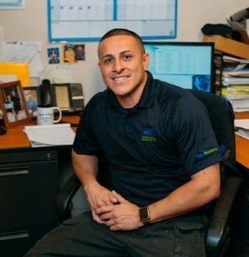 Photo of Rick Huron smiling at office desk in professional setting