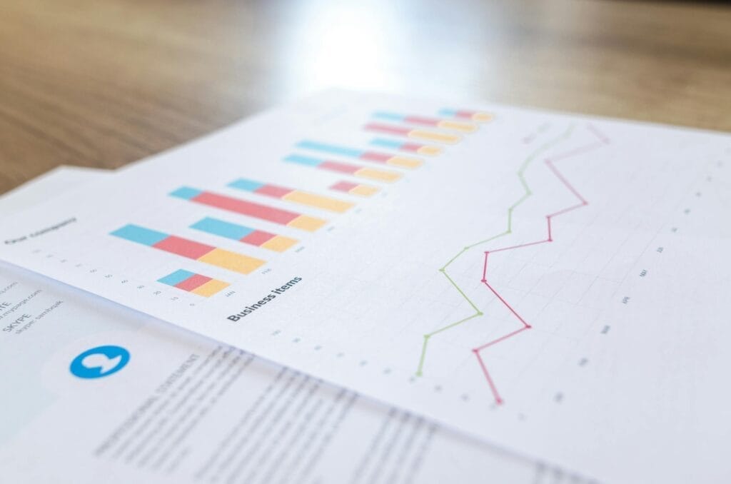 Business charts with bars and line graph on paper.