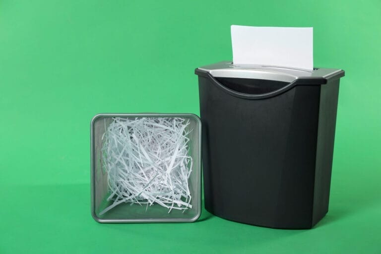 Paper shredder and bin with shredded paper.