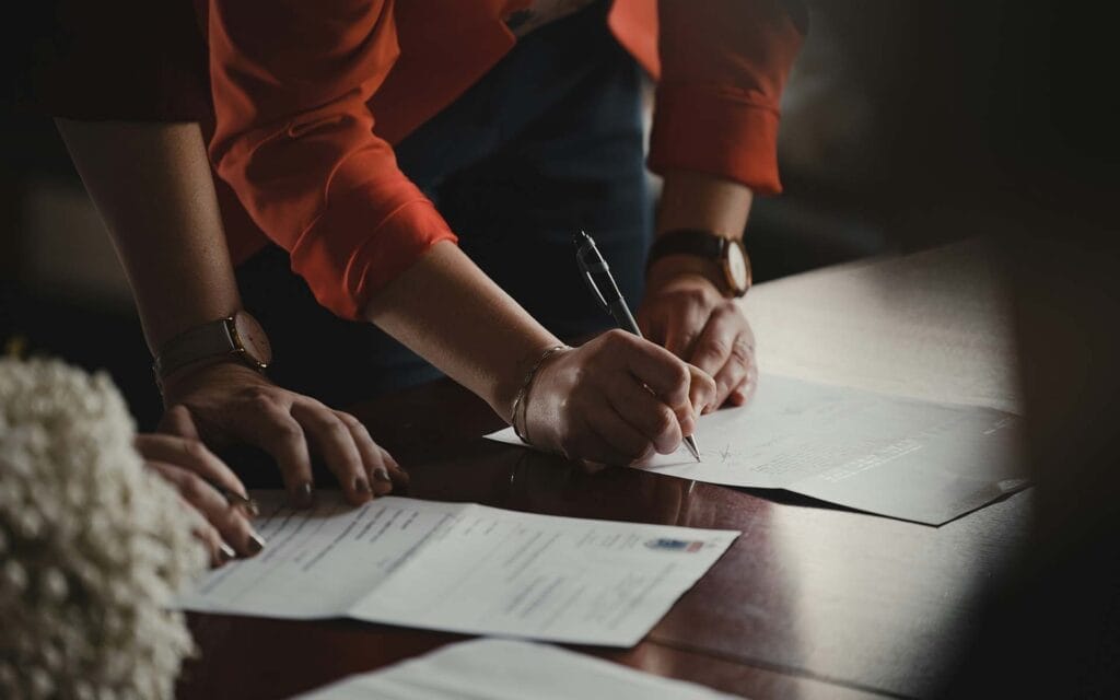 Person signing documents at a table.