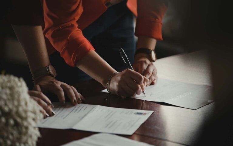 Person signing documents at a table.