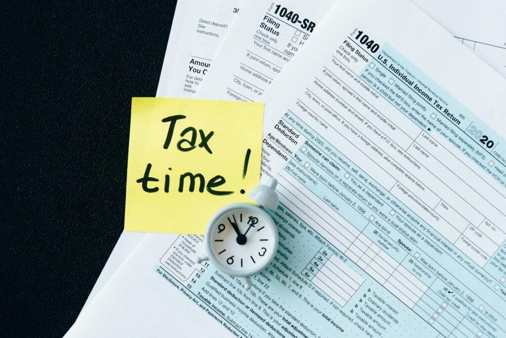 IRS tax forms with clock and reminder note