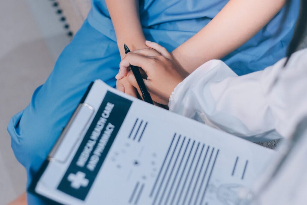 Nurse comforting patient, holding hands compassionately.