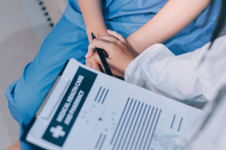 Nurse comforting patient, holding hands compassionately.