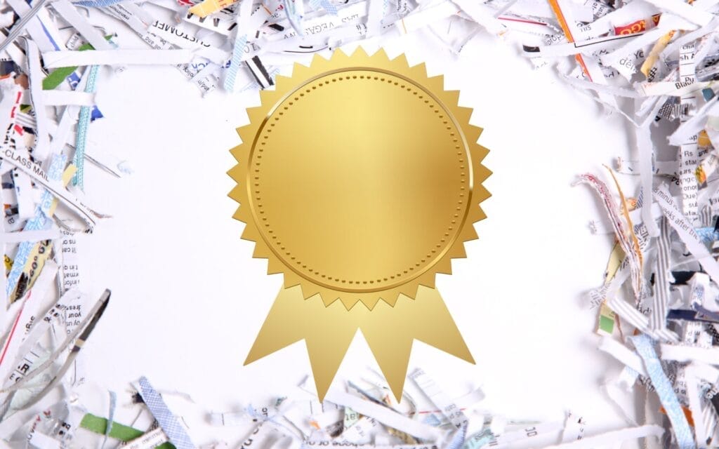 Gold medal on shredded paper background. Certificate of destruction