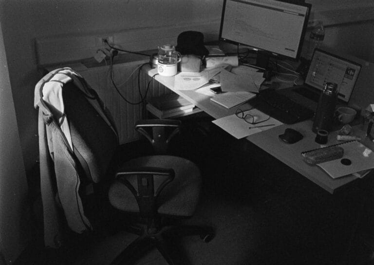 Black and white image of an occupied office desk setup in Compiègne, France.