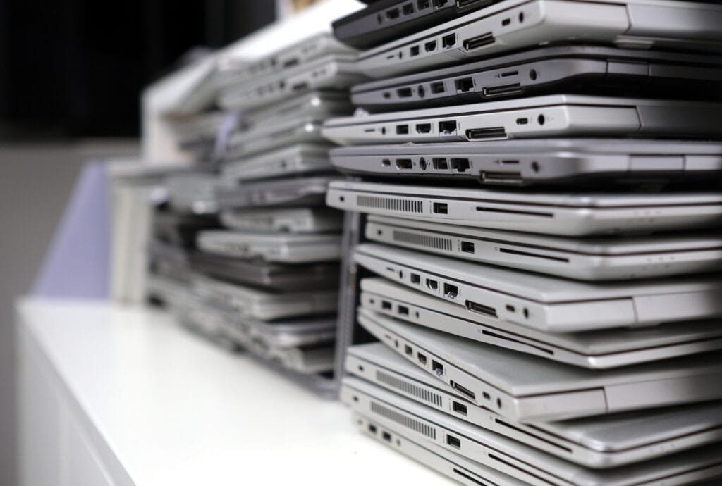 Rack with a stack of laptops in the storage room of a company waiting for e-waste shredding